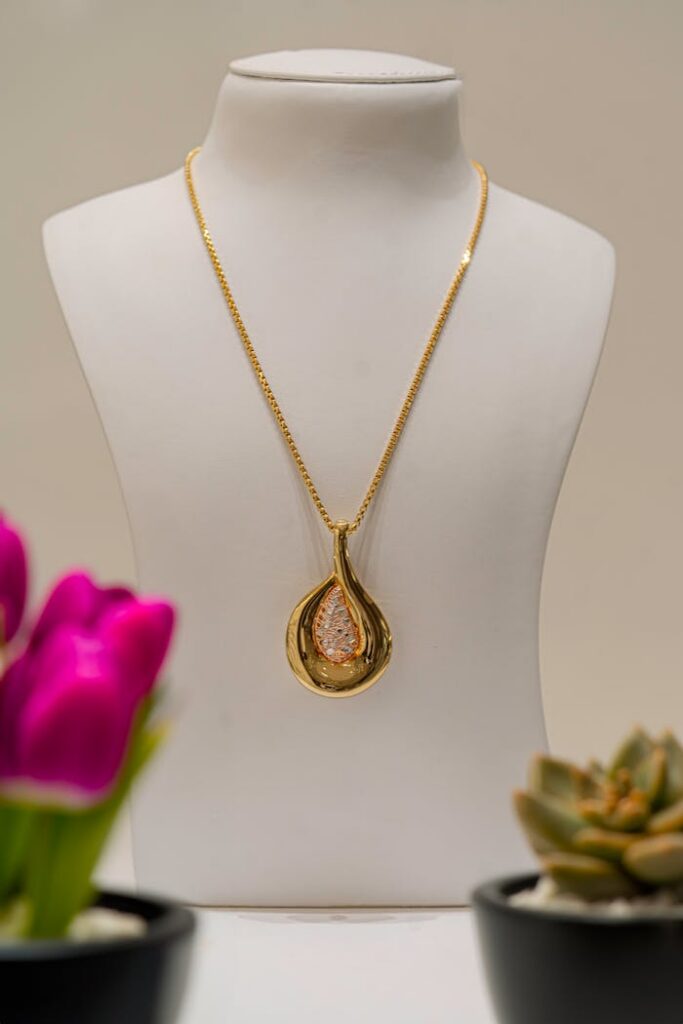 A sophisticated gold necklace displayed with vibrant flowers, perfect for luxury fashion.